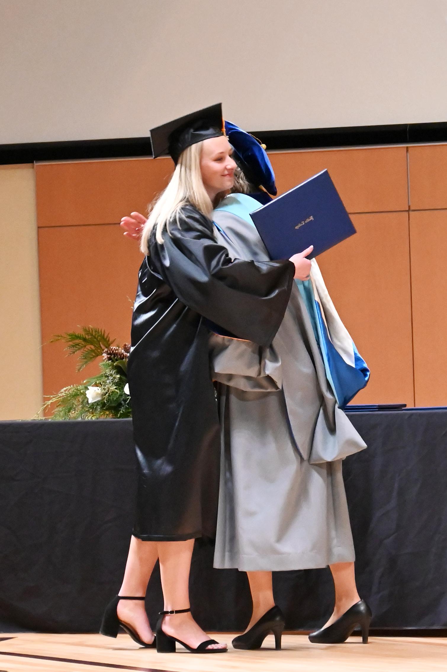 President Connie Boerst hugs female .graduate
